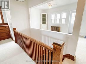 Toronto (Danforth Village-East York) apartment for rent - A room with a wooden staircase and a window with a view of a green tree.