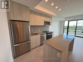 Milton (Cb Cobban) condo for rent - A modern kitchen with a stainless steel refrigerator and microwave.