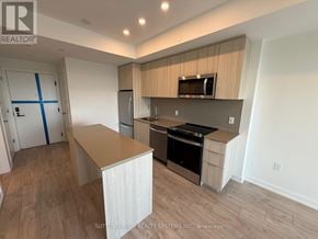 Milton (Cb Cobban) condo for rent - A kitchen with a wooden floor and white walls.