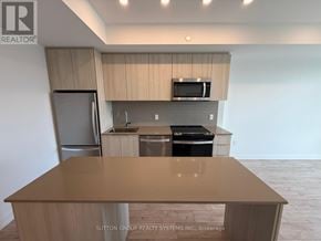 Milton (Cb Cobban) condo for rent - A kitchen with a refrigerator, microwave, and sink.