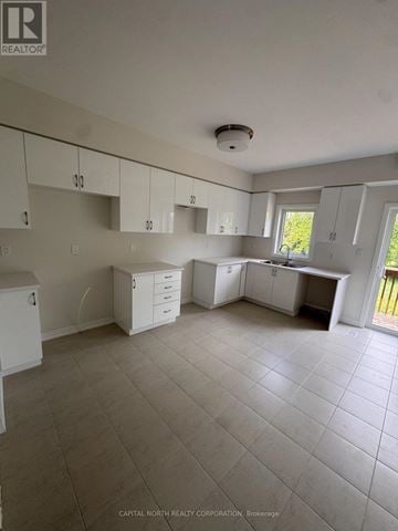 Brantford townhouse for rent - A white kitchen with tile flooring and white cabinets.