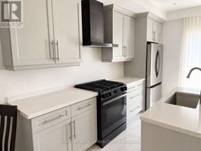 Brantford apartment for rent - A kitchen with white cabinets and black appliances.