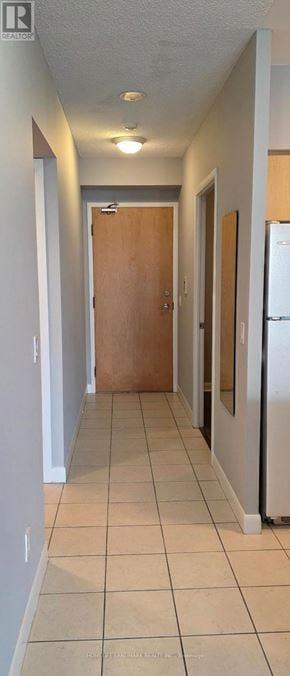 Toronto (Lansing-Westgate) condo for rent - A long hallway with a brown door at the end.