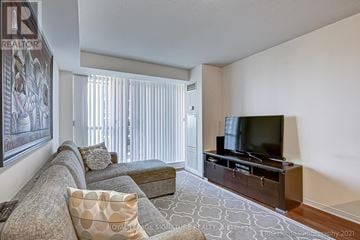 Toronto (Islington-City Centre West) condo for rent - A living room with a grey couch and a television.