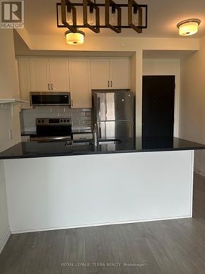 Brampton (Credit Valley) condo for rent - A kitchen with a stove top oven, microwave, and refrigerator.