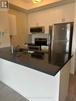 Brampton (Credit Valley) condo for rent - A modern kitchen with a black countertop and stainless steel appliances.