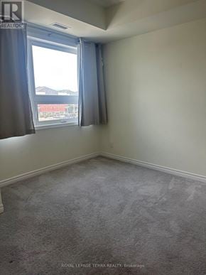 Brampton (Credit Valley) condo for rent - A room with a carpeted floor and a window with curtains.