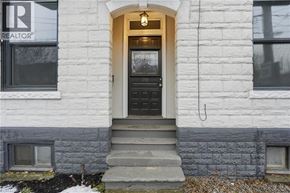 Hamilton apartment for rent - A white house with a black door and a REALTOR sign on the window.