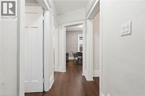Hamilton apartment for rent - A hallway with a chair and a table in the distance.