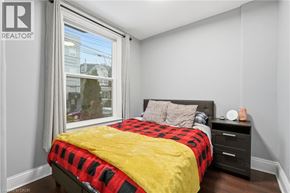 Hamilton apartment for rent - A bedroom with a bed, nightstand, and window.