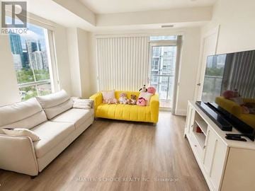 Toronto (Willowdale East) condo for rent - A bedroom with a white bed, a white dresser, and a window overlooking a grassy area.