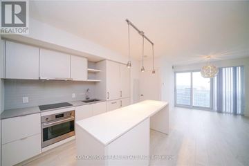 Toronto (Waterfront Communities) condo for rent - A modern kitchen with white cabinets and a large island.