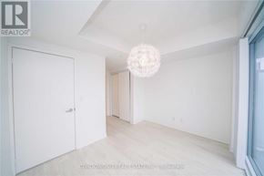 Toronto (Waterfront Communities) condo for rent - A white room with a chandelier and a door on the left.