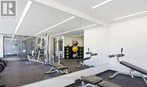 Burlington (Orchard) condo for rent - A gym with a variety of equipment including weights and benches.