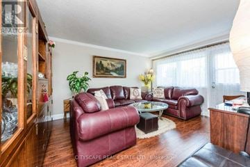 Toronto (Mimico) triplex for rent - A living room with red leather couches and a glass coffee table.