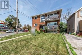 Toronto (Mimico) triplex for rent - A modern two-story house with a well-maintained lawn in front.