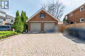Toronto (Mimico) triplex for rent - A house with a brick driveway and two garage doors.