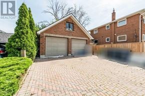 Toronto (Mimico) triplex for rent - A house with a brick driveway and a garage door.