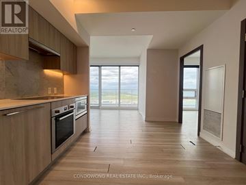 Toronto (Waterfront Communities) condo for rent - A kitchen with wooden cabinets and a large window.