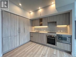 Toronto (Waterfront Communities) condo for rent - A modern kitchen with wooden cabinets and stainless steel appliances.