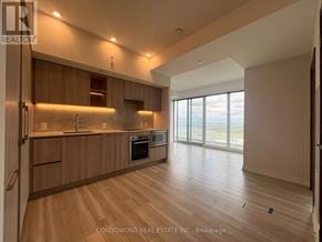 Toronto (Waterfront Communities) condo for rent - A spacious kitchen with wooden cabinets and a large window.