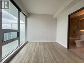 Toronto (Waterfront Communities) condo for rent - A room with a large window and a wooden floor.