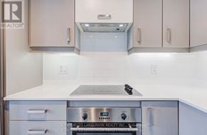 Markham (Unionville) condo for rent - A kitchen with a stove top oven and white cabinets.