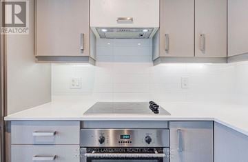 Markham (Unionville) condo for rent - A kitchen with a stove top oven and white cabinets.