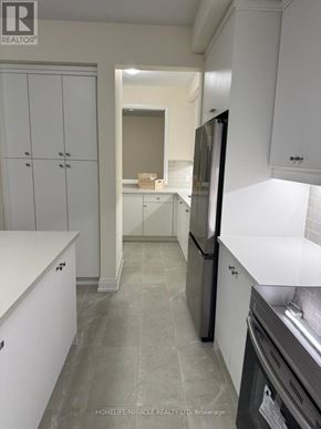 Springwater (Minesing) apartment for rent - A kitchen with white cabinets and a black fridge.