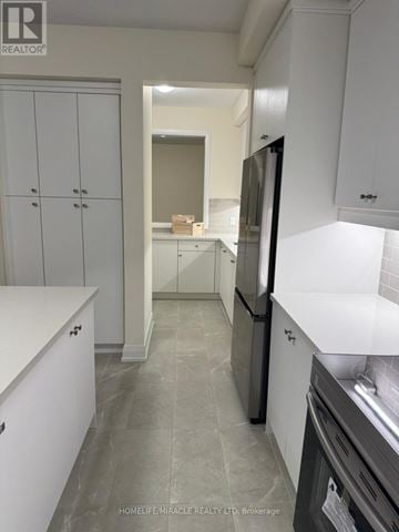 Springwater (Minesing) apartment for rent - A kitchen with white cabinets and a black fridge.