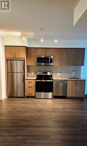 Toronto (Humber Heights) condo for rent - A kitchen with wooden cabinets and stainless steel appliances.
