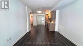 Toronto (Humber Heights) condo for rent - A spacious room with wooden floors and white walls.