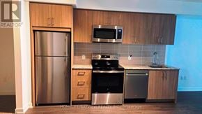 Toronto (Humber Heights) condo for rent - A kitchen with wooden cabinets and stainless steel appliances.