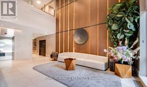 Mississauga (Hurontario) condo for rent - A modern office lobby with a reception desk and a large mirror on the wall.