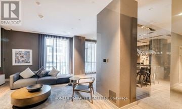 Mississauga (Hurontario) condo for rent - A living room with a grey couch and a wooden coffee table.