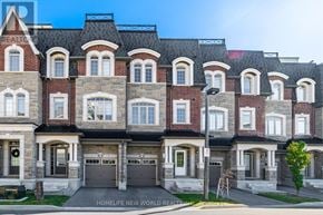 Vaughan (East Woodbridge) townhouse for rent - A large, multi-story residential building with a black roof and brick walls.