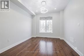 Vaughan (East Woodbridge) townhouse for rent - A room with wooden floors and a window with white curtains.