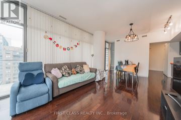 Toronto (Church-Yonge Corridor) condo for rent - A living room with a blue chair and a couch with pillows.