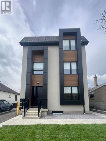 Toronto (Victoria Village) multi-family for rent - A modern two-story house with a black and wood exterior.