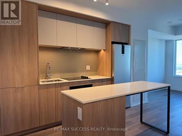 Mississauga (City Centre) condo for rent - A modern kitchen with wooden cabinets and a white countertop.