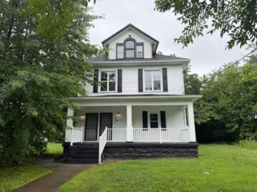 Louisville apartment for rent - A white house with a black roof and a porch.