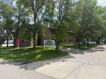 Glyndon apartment for rent - A building with a sign in front of it and trees in the background.