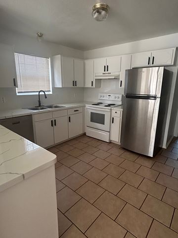 Killeen apartment for rent - A kitchen with white cabinets and a stainless steel refrigerator.