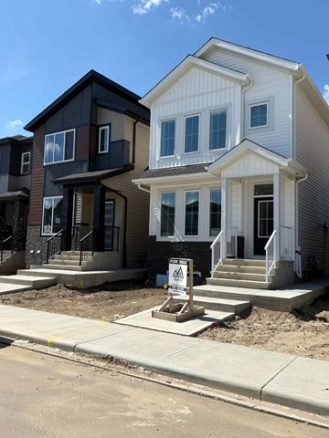 Leduc apartment for rent - A row of houses with a sign in front of the first one.