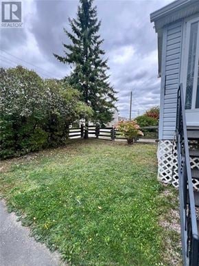 Sudbury apartment for rent - A small backyard with a fence and a tree.