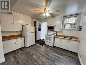 Sudbury apartment for rent - A kitchen with white appliances and wooden countertops.