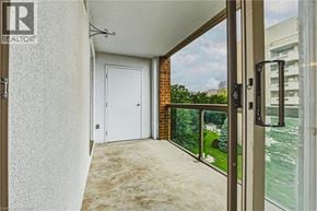 Burlington condo for rent - A balcony with a white door and a glass door leading to a view of a river.
