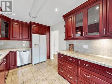 Vaughan (Brownridge) apartment for rent - A kitchen with red cabinets and a white refrigerator.