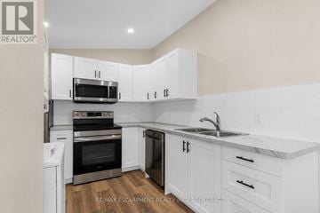 St. Catharines (E. Chester) apartment for rent - A white kitchen with a sink and cabinets.