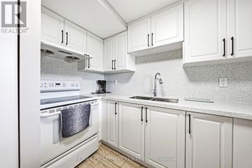 Burlington (Brant) condo for rent - A white kitchen with a stove top oven and a sink.